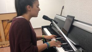 Lorena cantando y acompañándose con el piano.